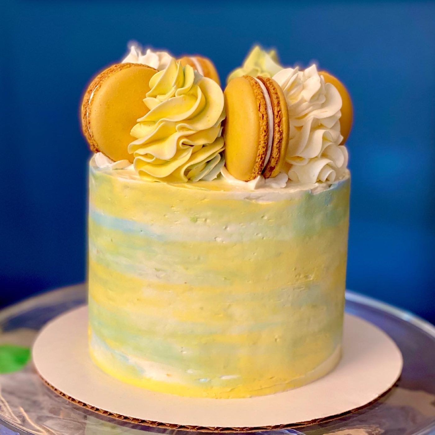Watercolor buttercream cake topped with macarons